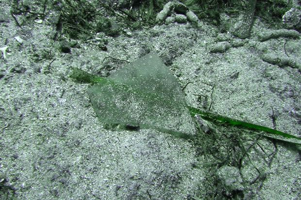 (Photographie) Fragment de verre à vitres découvert sur le site de fouilles (Crédit DRASSM)
