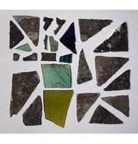 Photographie : Aperçu des teintes que peuvent présenter les vitraux (diverses nuances de vert et de bleu) (crédit L. Pirault / INRAP, 2005)