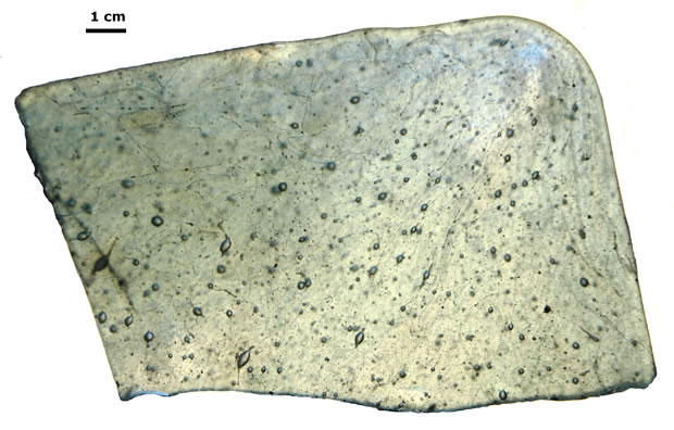(Photographie) Détail d’un fragment (coin) à nombreuses bulles ovoïdes (Crédit DRASSM)