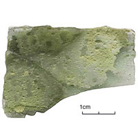 Photographie : Serris les Ruelles, habitat aristocratique, 10e-11e siècles, fragment de verre altéré (crédit F. Gentili / INRAP)